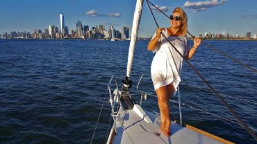 Model on sailboat with Manhattan Skyline