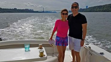 Married couple on a motor boat near the George Washington Bridge